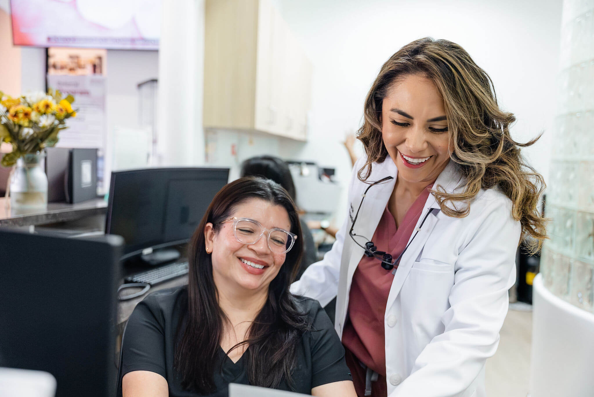 ChatGPT said:Dentist and dental assistant smiling while reviewing patient information at the clinic